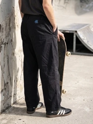Adidas skateboarding x Maxallure track slacks skate pants - Jag säljer dessa Track Slack-skatebyxor från adidas x maxallure-kollektionen. De är tillverkade i ett slitstarkt, svart canvas-nylonmaterial. Den avslappnade konstruktionen med elastisk midja har en ljusblå logobrodyr ovanför bakfickorna, medan veck och pressveck längs midjan ger en vintage-känsla. Byxorna är byggda för att tåla kraven från skateboarding samtidigt som de bibehåller en ren och klassisk estetik, vilket ger den perfekta balansen mellan slitstyrka, rörlighet och streetwear-känsla. 