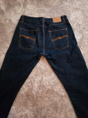  Nudie Jeans BIG BENGT *VINTAGE *RARE 34x34 -  Nudie Jeans Vintage modell BIG BENGT Dry heavy discontinued i Toppskick! Jeansen har rak passform och är tillverkade i slitstark denim.                       Storlek 34w-34L