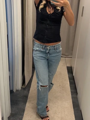 Ljusblå raka jeans med slitning - Säljer ett par ljusblå jeans med rak passform och slitningar.
