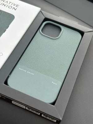 Grönt Native Union iPhone 15 skal - Nytt!  - Snyggt mobilskal till iPhone 15 från Native Union i en matt grön färg. Skalet har en texturerad ovandel och slät nederdel, tillverkat av växtbaserade material. Magnetiskt och designat för extra stötskydd. Perfekt för dig som vill ha både stil och funktion.