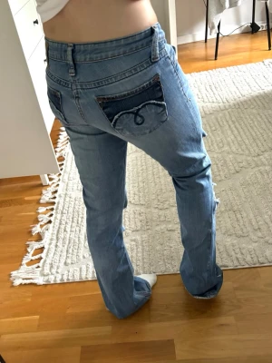 Ljusblå bootcut jeans - Säljer ett par ljusblå bootcut jeans från Mavi med unika bakfickor i mörkare denim och broderade detaljer. Säljer då de tyvärr är för små för mig🥰