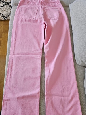 NYA! Rosa Idun high waist jeans - Slutsålda (Passar M/L) -  Lappen säger XL, men de är väldigt små i storleken och saknar stretch.De mater 40 cm midjan och passar därför bäst dig som brukar na storlek 38 eller 40 (M/L).  ldun är i stum denim utan stretch, upplever många att man behöver gå upp en eller två storlekar mot vad man brukar ha  Midjehoid: 32 cm (Super High Waist! • Innerbenslängd: ca 85 cm (Perfekt för långa ben)  • Benöppning: 25 cm (Trendigt vida ben)superenkla att förkorta siälv om de är för långa - det är bara att klippa av dem 