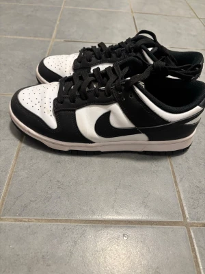 Svarta och vita Nike Dunk Low sneakers - Säljer ett par klassiska Nike Dunk Low sneakers i svart och vitt. 