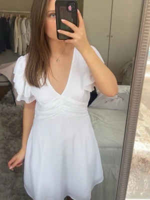Superfin Studentklänning från bubbleroom  - Fin vit studentklänning med volanger och andra fina detaljer, aldrig använts (bara provas) varav priset❤️ pris kan diskuteras! 