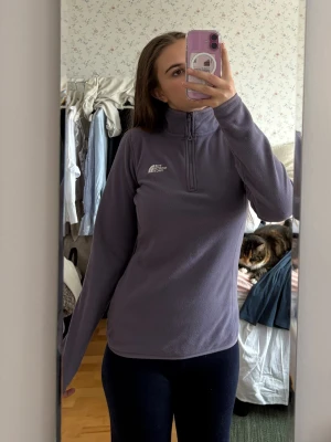 Lila fleece från The North Face - Mysig lila fleece med 1/4 dragkedja från The North Face. Använd 2 ggr i fjällen endast i stugan och den var jätte härlig men den är tyvärr lite för liten för mig. 