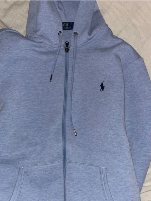Ljusblå hoodie från Polo Ralph Lauren - Återuppladdning av en annons! Jag säljer denna riktigt snygga ljusblåa ziphoodie från polo Ralph lauren som knappt har kommit till användning den passar Xs/S och runt dig som e 170-178 typ, skick är runt 9.5/10! Använd fåtal gånger ca 5 gånger, den har blivit för liten för mig och ligger bara i garderoben och tar plats så hör av dig vid intresse! Start pris 1150 kan gå ner vid en snabb affär, ny pris och köpt för 2200 i Ralph laurens butik! 