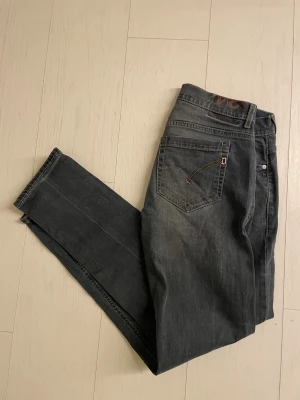 Dondups  - Snygga mörkgrå jeans från dondup med klassisk femficksmodell . Jeansen har subtila slitningar och kontrastsömmar på bakfickorna. Perfekta för en avslappnad och trendig stil.