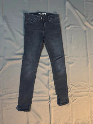 Mörkblå skinny jeans från Karve - Snygga mörkblå skinny jeans från Karve med klassisk femficksdesign och dragkedjegylf. Jeansen har en smal passform och är tillverkade i stretchigt denimtyg som sitter bekvämt. Perfekta för en trendig och avslappnad stil.