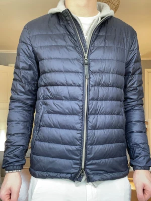 Woolrich Lightweight Down Jacket Navy Strl S - Woolrich lättvikts dunjacka i mörkblå färg. Perfekt vår/höst eller som mellanlager vinter.  Storlek S – normal passform. Mycket fint skick.  Original Woolrich – John Rich & Bros.  Nypris ca 3000+ kr. Säljes pga används inte längre. 