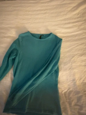 Turkos cashmeretröja från Cachemire - Superskön turkos stickad tröja från Cachemire. Tillverkad i mjuk cashmere, har rund halsringning och långa ärmar. Perfekt för dig som gillar stilrena och bekväma plagg med en poppig färg.