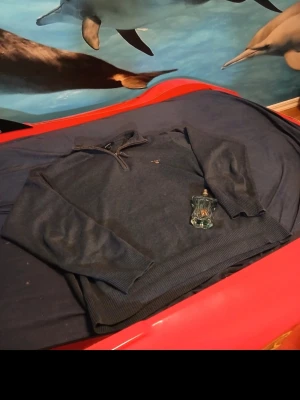 Mörkblå halvzip tröja från Gant - Snygg mörkblå stickad tröja från Gant med halv dragkedja och diskret logga broderad på bröstet. Tröjan har ribbade muddar vid ärmslut och nederkant, perfekt för en stilren och avslappnad look.