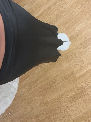 Svart långkjol i satinlook - Säljer en svart långkjol med lätt utsvängd passform och slät midja. Kjolen har en mjuk satinliknande yta som ger ett elegant intryck. Perfekt att styla med både sneakers och boots för en trendig look.