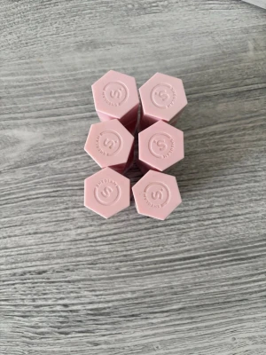 Set med rosa läppstift från Sheglam - Säljer ett set med sex läppstift från Sheglam. Hylsorna är ljusrosa och har en unik sexkantig form med gulddetalj. Perfekt för dig som gillar snygg och modern design på sminket. Färgerna på stiften varierar och ger flera valmöjligheter.