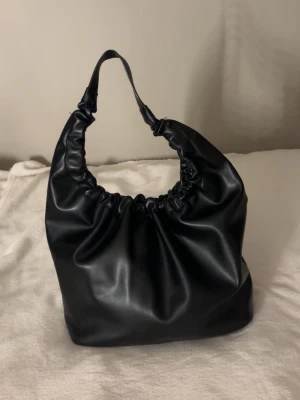 Svart scrunchie-handväska Gina Tricot - Stor och fyllig väska. Perfekt till idrott eller stranden!