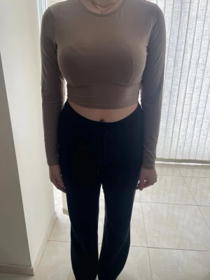 Beige croppad långärmad topp 157 - Trendig beige croppad långärmad topp från 157. Enkel och stilren design med rund halsringning, perfekt att matcha med höga byxor eller kjol. Mjuk och stretchig känsla för en bekväm passform.