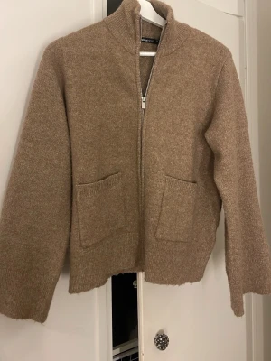 Stickad zip kofta - Jättefin beige/brun stickad zip kofta från Gina tricot. Storlek XS, mycket fint skick 💕Använd cirka 1 gång men kände att den va lite för liten ☀️