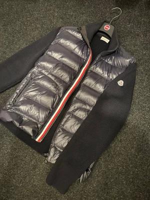Moncler tricot cardigan down. - Moncler cardigan i mycket bra skick. Endast använd fåtal gånger. Nyligen kemtvättad. Storlek L men passar även M. Nypris 11.000kr.  Skicka meddelande vid frågor. Priset går att diskutera något vid SNABB OCH SMIDIG affär. 
