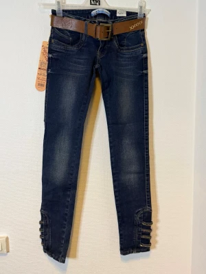 Mörkblå skinny jeans med bälte - Midjan 34 cm  Längd 90 cm  Benvidd 22 cm 