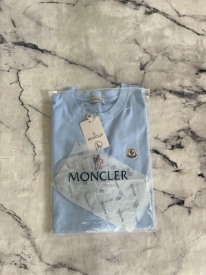 Monclear T-shirt - En mycket fin aldrig använd T-shirt ifrån monclear. T-shirten har aldrig använts därmed i nyskick. Säljs pga för stor u storlek:)  Priset kan diskuteras!