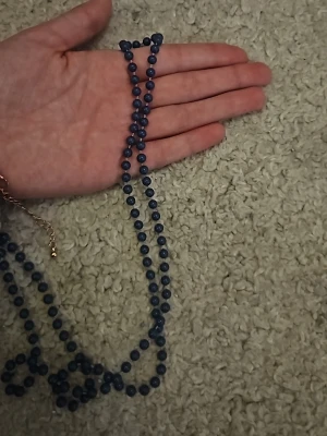 Blått halsband med pärlor - Snyggt halsband med runda, blå pärlor trädda på rad. Halsbandet har en enkel och stilren design som passar till många olika looks. Perfekt för dig som gillar accessoarer med färg och vill sticka ut lite extra.