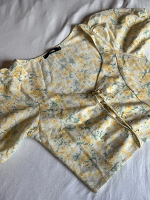 Blommig omlottopp med snörning - Supersöt blommig crop topp från Bik Bok. Nyskick.