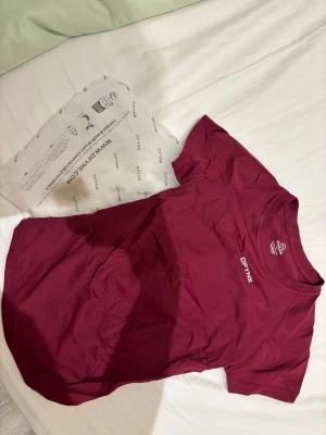 Impact short sleeve dfyne - Vinröd t-shirt från DFYNE med vit logga på bröstet. Sitter super fint på. Ej använd.