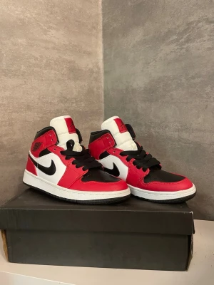 Nike Air Jordan 1 Mid - Air Jordan 1 mid i storlek 39. De är i princip oanvända men har två små märken på sig av som man ser på bilderna. Lådan finns kvar men den är lite sliten.