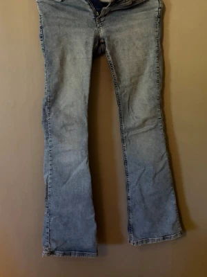 Ljusblå bootcut jeans Perfect jeans - Säljer ett par ljusblå bootcut jeans med råa kanter nertill. Jeansen har klassisk femficksdesign och normalhög midja. Tillverkade i denim med en avslappnad passform och lätt utsvängda ben. Perfekta för en casual och trendig look. 
