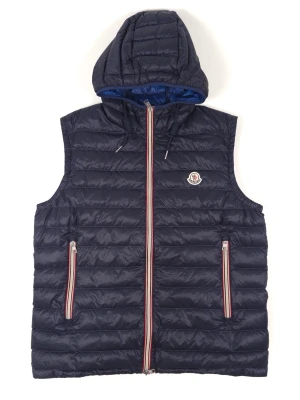Moncler Naples Hooded Vest - Information: Moncler Naples Hooded Vest in navy blue nylon. Stand-up collar with drawstring. Emblematic tricolor border. Felt logo patch on the front. Zip closure. Two zipped pockets. Contrasting lining in bright blue nylon. 100% polyamide.  Condition: The Vest has been gently used and is in very good condition.    Pit to Pit: 58.5 cm / 23 Inches Chest: 117 cm / 46.1 Inches Length: 69 cm / 27.2 Inches