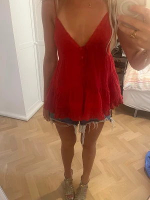 Röd topp från Urban Outfitters  100% bomull  - Super fint slutsålt linne från kimchi blue (urban outfitters). Nypris ca 550, 100% bomull! Ena bandet är trasigt men som jag knutit på, skriv för bild privat! 