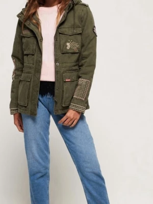 Vintage Superdry Olivgrön vindjacka med broderier - Snygg olivgrön vindjacka med flera fickor, huva och unika broderade detaljer i vitt och rosa på bröst, ärm och muddar. Jackan har patch på ärmen och mysigt foder på insidan. Perfekt för dig som vill ha en cool och personlig stil.