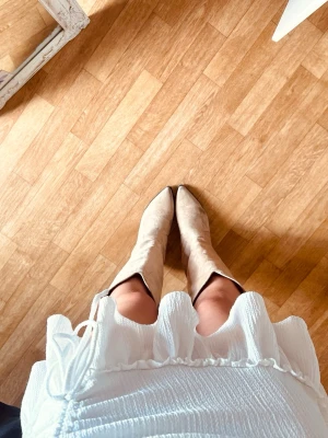Vit kortkjol från Ginatricot med volang och snörning - Superfin vit kortkjol från Gina Tricot med volangkant och snörning i sidan. Kjolen har en tight passform och passar XS 🌺
