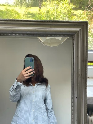 Randig blåvit skjorta med knappar - En Ralph Lauren skjorta använd fåtalet gånger. Inga defekter. I storlek M men passar perfekt på mig som varierar mellan XS och S. Pris kan diskuteras vid snabba köp!