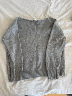 Grå stickad tröja med båtringning - Mysig grå stickad tröja med båtringad hals och långa ärmar. Storlek one size men jag skulle säga att den sitter som ungefär S. Köpt för 632 kr. 