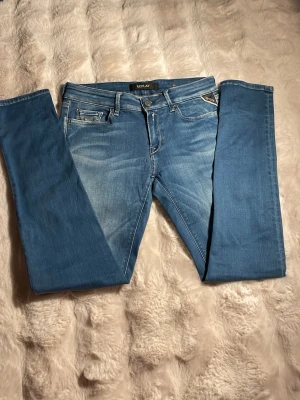 Blå Replay jeans sitter som GROVER - Snygga blå jeans från Replay med slim fit och klassisk femficksdesign. Jeansen har ljusa slitningar framtill och bakfickor med dekorativa sömmar. Perfekta för en trendig och avslappnad look. W29 L30