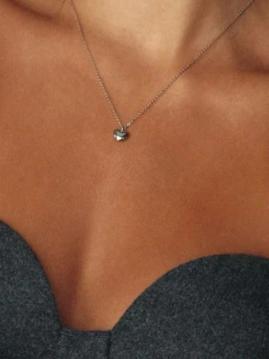 Silverhalsband med hjärtberlock edblad - Ett stilrent halsband i silverfärgad metall med en liten, blank hjärtformad berlock. Kedjan är tunn och diskret, vilket gör att hjärtat står i fokus. Perfekt för dig som gillar minimalistiska smycken med en romantisk touch.