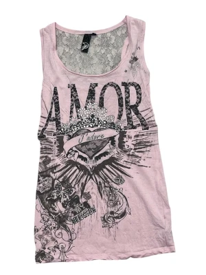 Rosa linnetopp med spets och tryck - Snygg rosa linnetopp med stort svart tryck 'AMOR' och dekorativa detaljer framtill. Baksidan har en transparent spetsdel upptill med blommönster. Perfekt för dig som vill sticka ut lite extra.