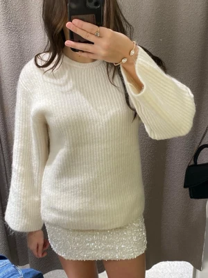 Vit stickad tröja med rosett i ryggen - Superfin vit stickad tröja med breda ärmar och öppen rygg som knyts med en rosett i ryggen. Den är knappt använd! 