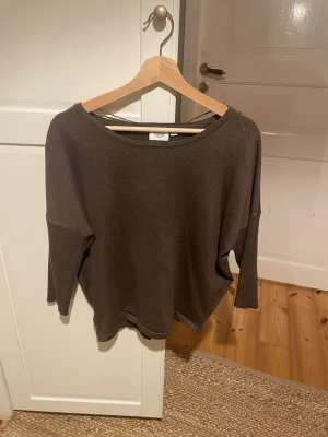 Brun oversized tröja från Saint Tropez - Mjuk och enkel brun tröja från Saint Tropez med avslappnad, oversized passform och trekvartsärmar. Tillverkad i tunt, stretchigt material och har en bred rund halsringning. Perfekt för en chill och stilren look.