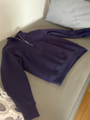 Mörkblå half-zip hoodie - En stilren mörkblå hoodie med half-zip dragkedja framtill och ribbade muddar vid ärmslut och midja. Hoodien har en klassisk passform och är tillverkad i mjukt sweatshirtmaterial. Perfekt för en avslappnad look. Hel ny 