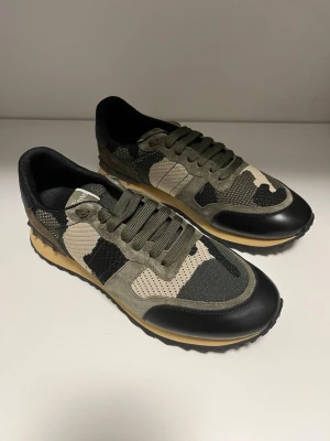 Camo sneakers från Valentino - Snygga Valentino Garavani sneakers med ett coolt camouflage-mönster. Skorna har snörning och en kombination av gröna och svarta detaljer, Passar även bra på storlek 44