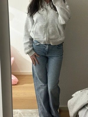 Blå raka jeans med hög midja - Säljer ett par klassiska blå jeans med rak passform och hög midja. Jeansen har fem fickor och stängs med dragkedja och knapp. Perfekta till en avslappnad stil och lätta att matcha med olika toppar.