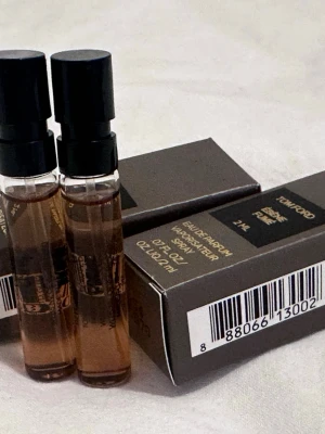 Tom Ford Ébène Fumé EdP 2 ml - Exklusiv parfymprov från Tom Ford, Ébène Fumé Eau de Parfum i 2 ml sprayflaska. Flaskan är genomskinlig med svart spraylock och doften kommer i en elegant brun kartong med guldfärgad text. Perfekt för dig som vill testa en lyxig och rökig doft.
