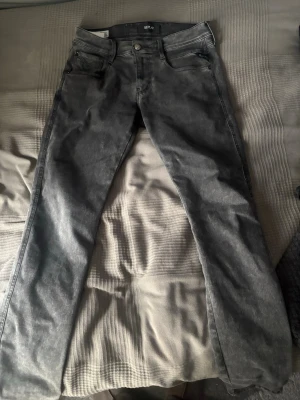 Grå jeans från Replay - Snygga grå jeans från Replay med klassisk femficksdesign och raka ben. Jeansen har en tvättad look och är tillverkade i denim med en skön passform. Perfekta för dig som gillar en avslappnad men stilren stil.