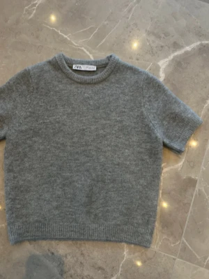 Grå stickad t-shirt från Zara - Kortärmad stickad t-shirt i mjuk grå ull från Zara. 