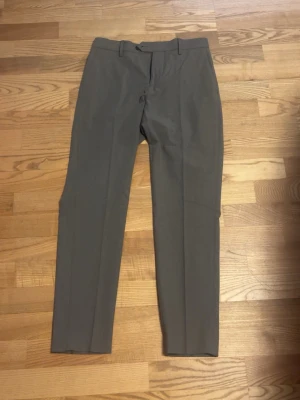 Gråa kostymbyxor  - Säljer ett par helt nya kostymbyxor från bläck. Lapparna är avklippta!