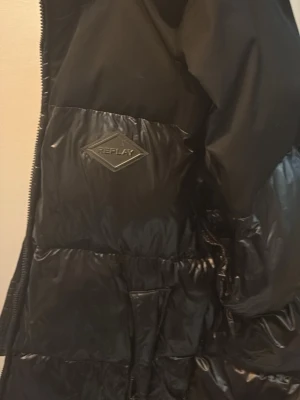 Svart dunväst från Replay - En lite tjockare väst från replay otroligt skön och snygg med glansiga materialet. Köpt förra våren för 899kr