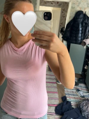 Ljusrosa ärmlös linnetopp - Säljer en ljusrosa ärmlös linnetopp med rund halsringning. Toppen har en slim passform och är tillverkad i ett mjukt material som passar perfekt till jeans eller kjol. Enkel och stilren design som är lätt att matcha.