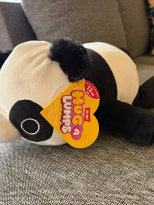 NY! ZURU Hug A Lumps Panda Pete 1,5kg gosedjur - Supermjuk och gosig panda från Hug a Lumps-serien av Zuru. Pandan är svartvit med stora runda öron och broderade detaljer på ansiktet. Perfekt som kramkompis eller dekoration. Vikt ca 1,5kg. NY I KARTONG!