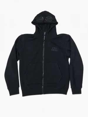 Svart zip hoodie med glasögon - Säljer en svart zip hoodie med nedfällbara glasögon/goggles som passar personer mellan 160-166 cm. Tröjan är i mycket fint skick och har bara använts ett fåtal gånger.